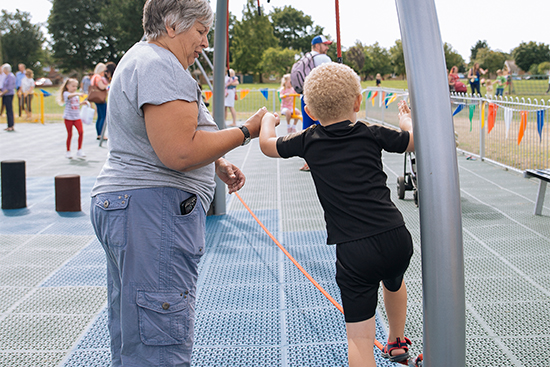 grandmother helping boy across a balance rope
